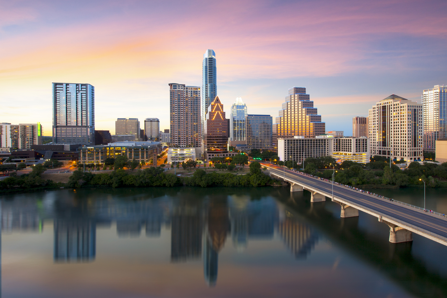 From the top floor of the Hyatt on Ladybird Lake, this Austin Skyline Picture was captured at sunset. Prominently displayed are the Austonian (the tallest building in Austin) and the iconic Frost Tower. In the foreground is Town Lake and Congress Bridge.